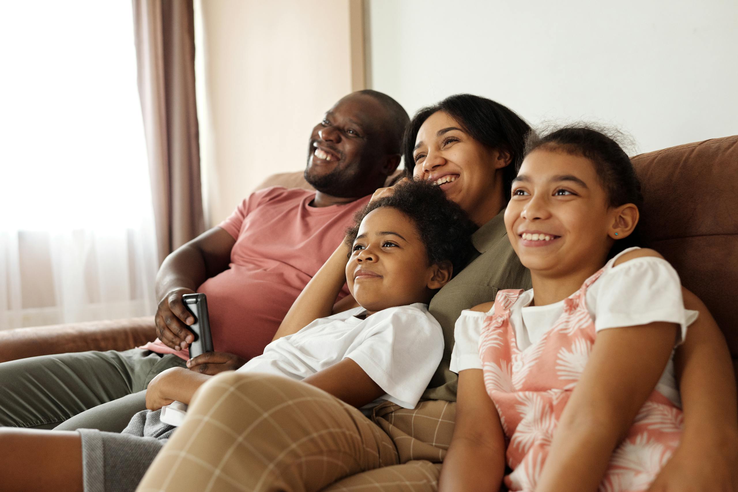 Happy multicultural family enjoying quality time together on a sofa at home.